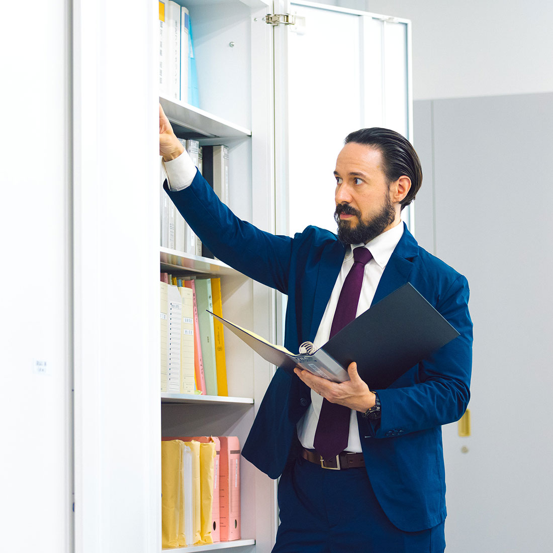 書類を探す国際営業の男性社員