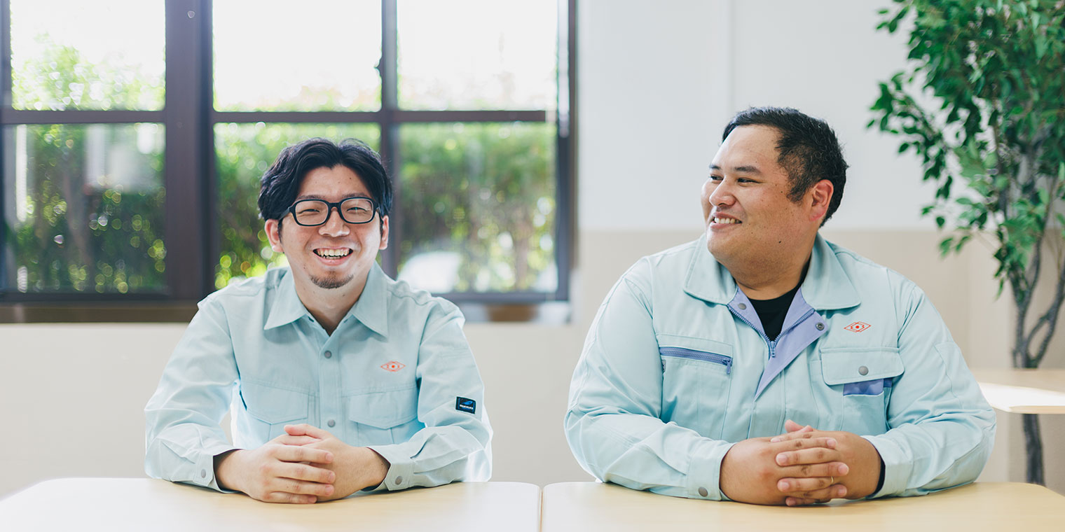 笑顔で工場見学を呼びかける男性社員2人