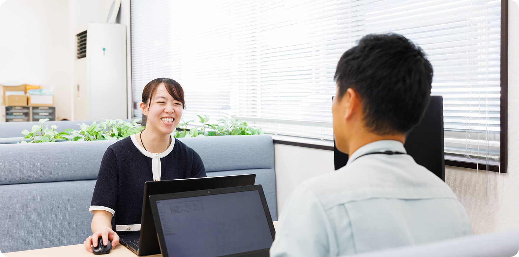 部署の垣根を超えてコミュニケーションをとる女性社員と男性社員